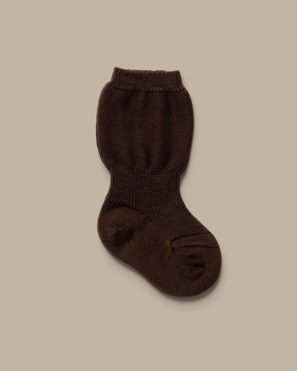Varig brown baby socks made from organic wool with a ribbed cuff for a secure fit on a neutral background.